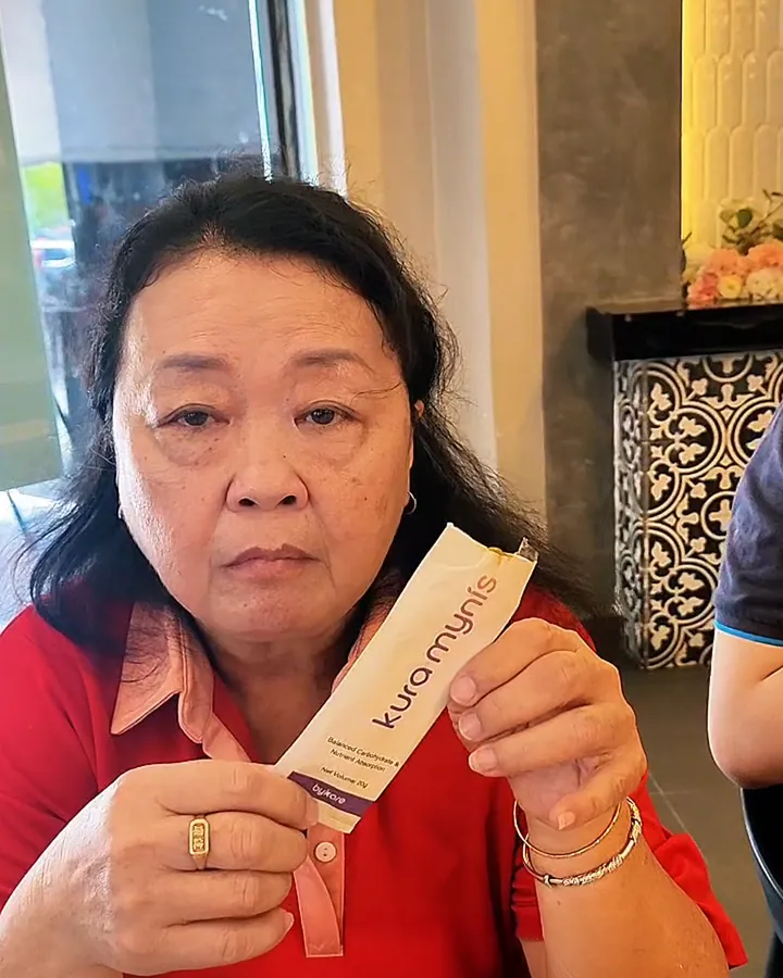 Kura Mynis customer holding a sachet